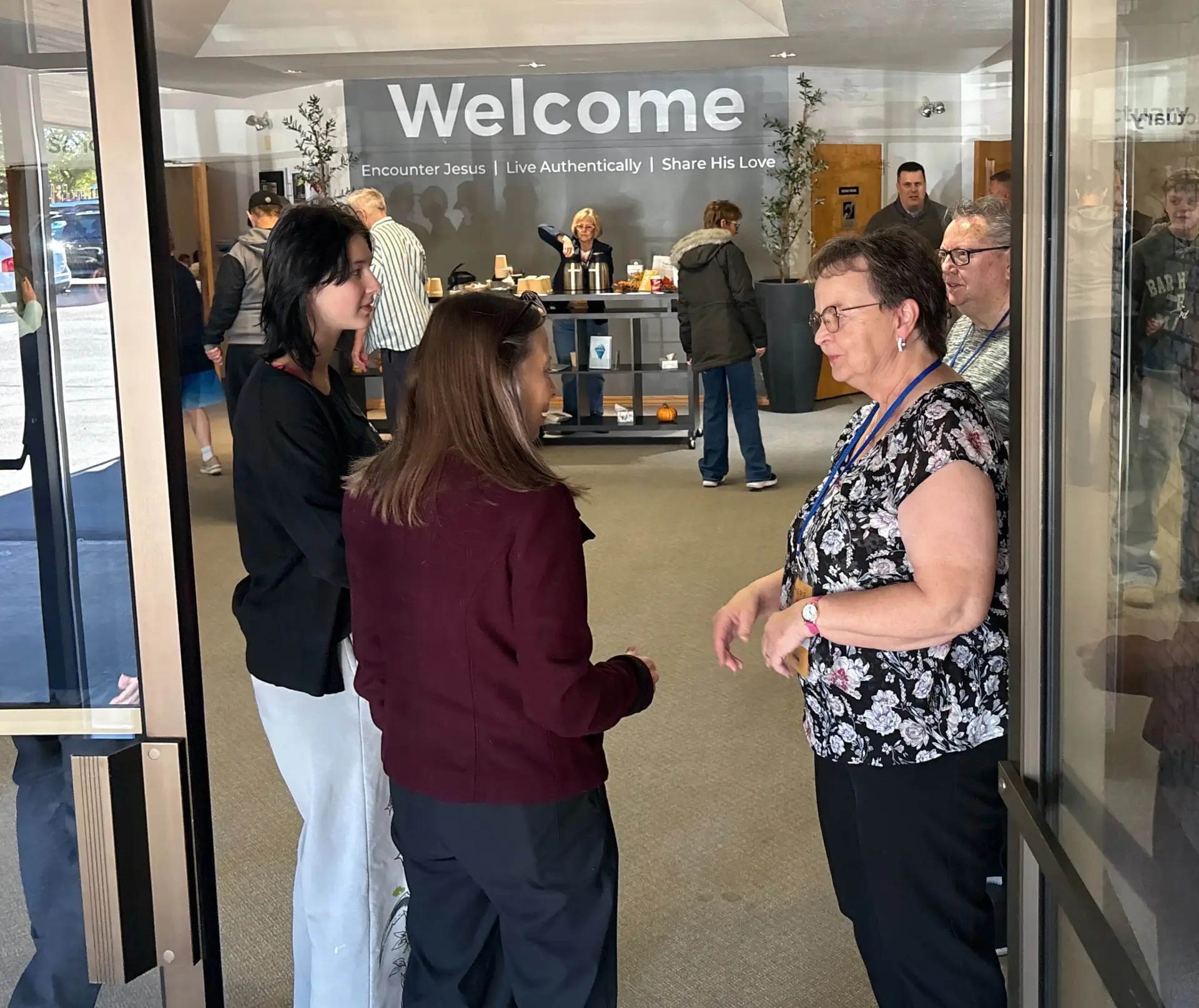 Members greeting each other in Trailview’s front entrance under the Welcome sign